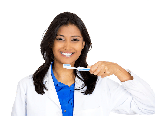 A periodontist in Carson City, Nevada, holding a toothbrush to her mouth while smiling.