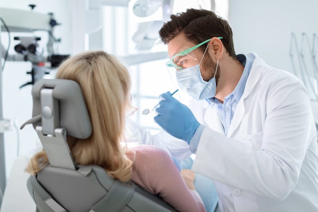 A dentist checking their patient's teeth after a root canal.