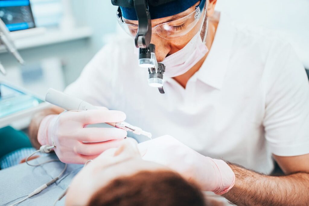 A dentist performing a root canal on their patient.
