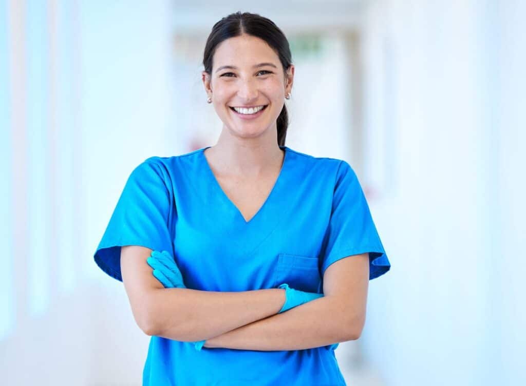 A female general dentist smiling with her arms crossed for a photo.