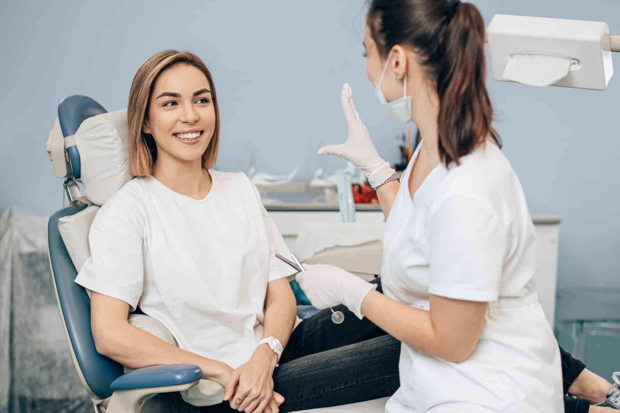woman smiling in chair while her dentist explains the procedure.