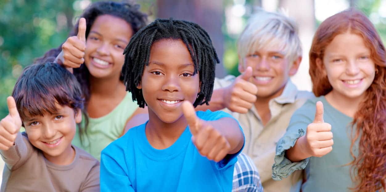 A group of five kids in Minden, NV smiling and giving a thumbs up