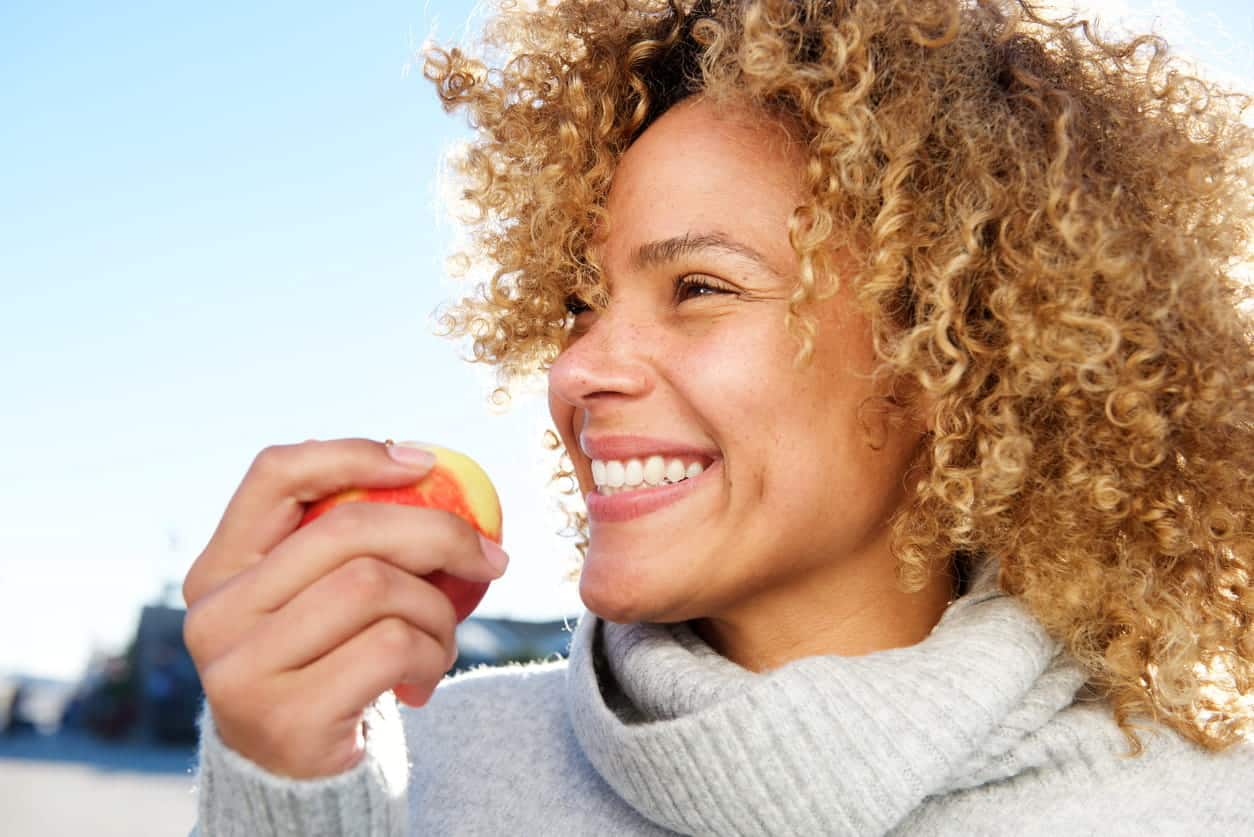 A woman smiling in Sparks, NV while holding an apple