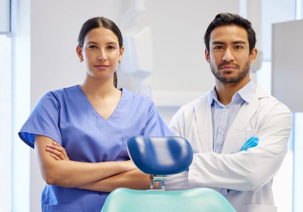 A dentist holding a tooth X-Ray showing tooth roots.