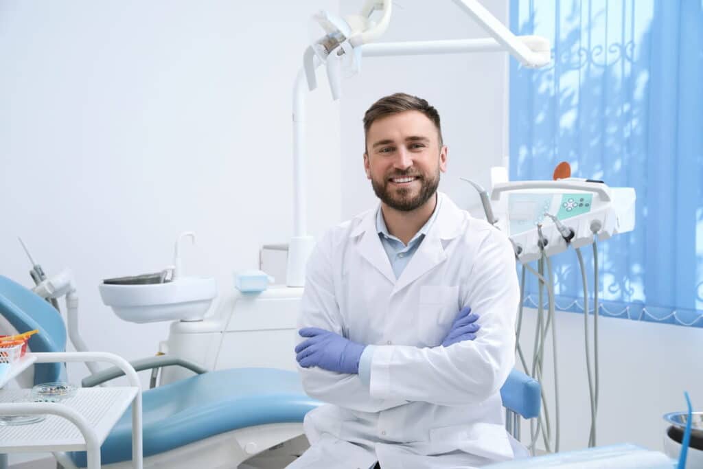 A dentist in Sparks, Nevada, smiling with his arms crossed.