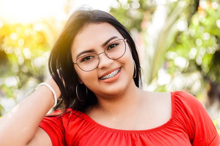 A young woman smiling with metal braces. 