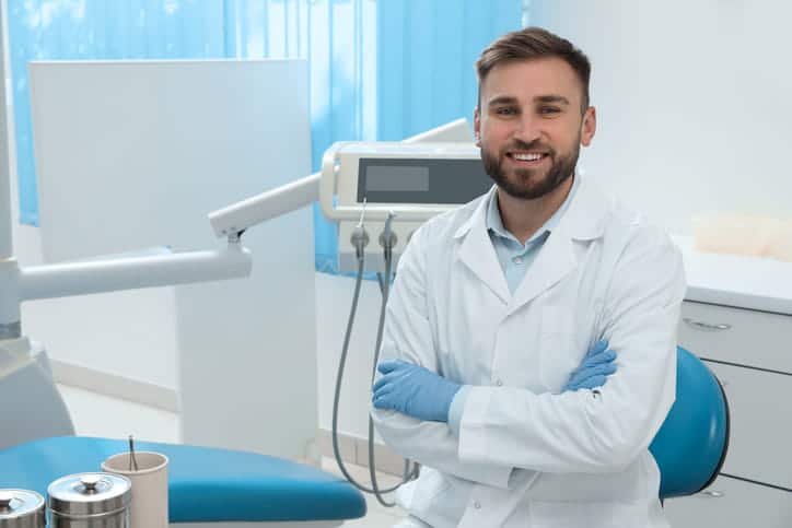 A dentist with his arms crossed, smiling for the camera. 