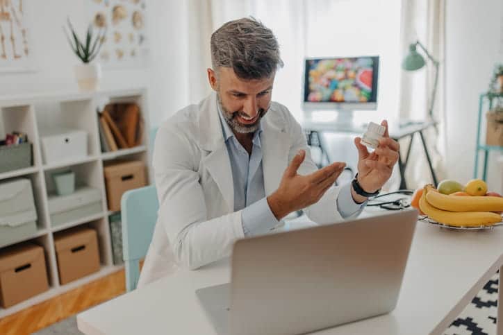 A dentist explaining a medication to a patient during a teledentistry visit. 