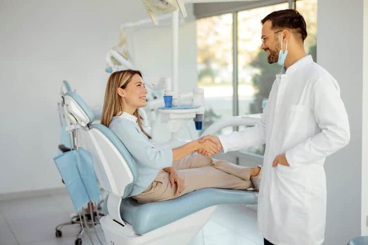 A woman shaking hands with her new dentist. 