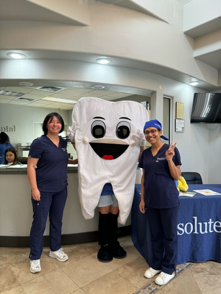 Two absolute dental employees with mascot at adult dental day.