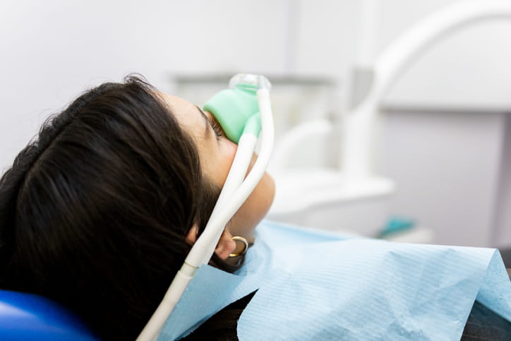 A woman getting sedated at her dental appointment.