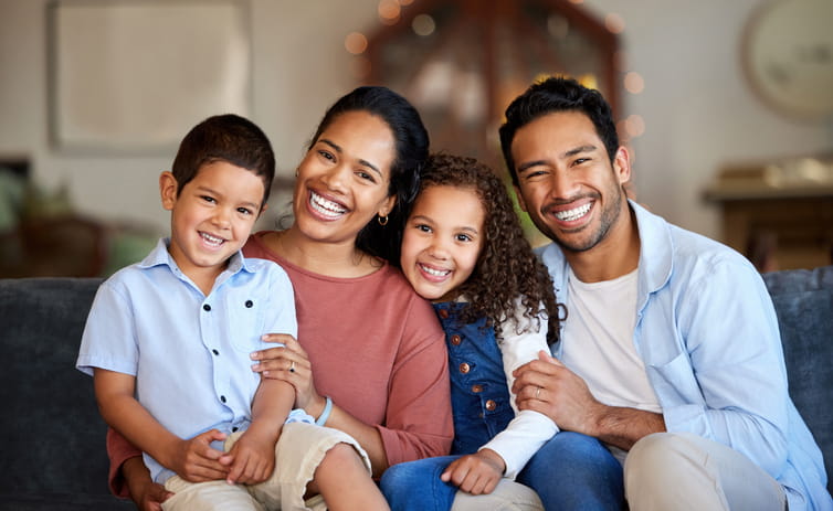 A family of four smiling together. 