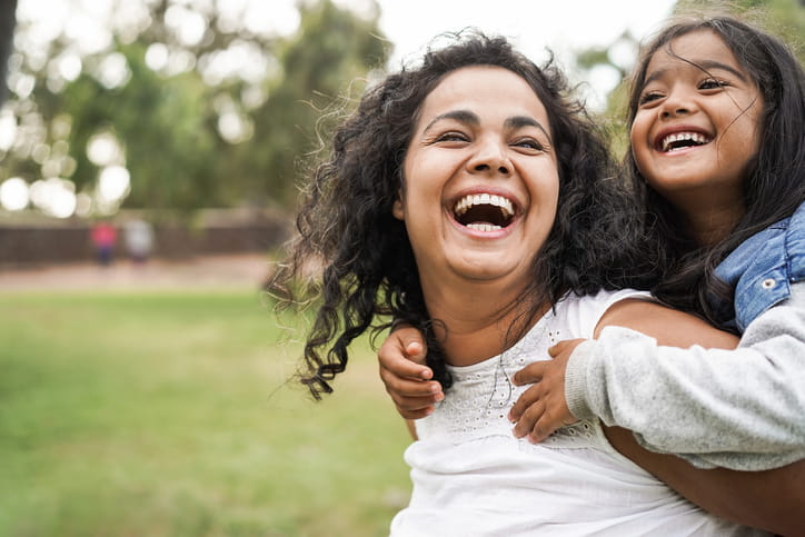 A mother and daughter smiling and laughing together.
