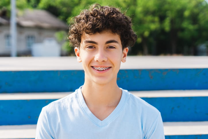 A boy smiling with metal braces. 