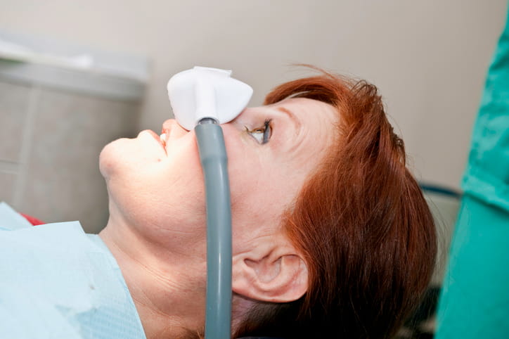 A woman with a Nitrous Oxide device covering her nose for a dental appointment.
