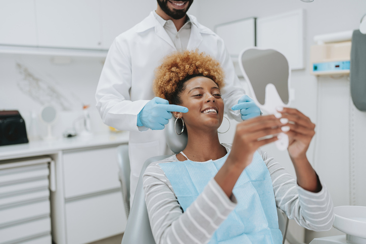 Start The New Year Right With A Dental Check Up 1 Woman at dentist holding mirror