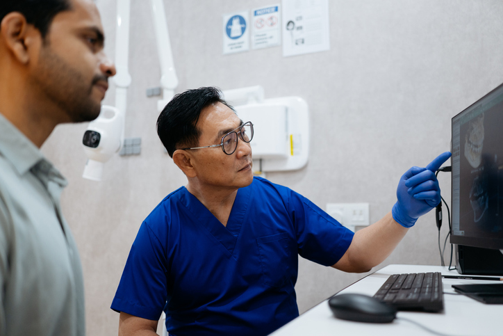 Oral health specialist reviewing scan images with patient